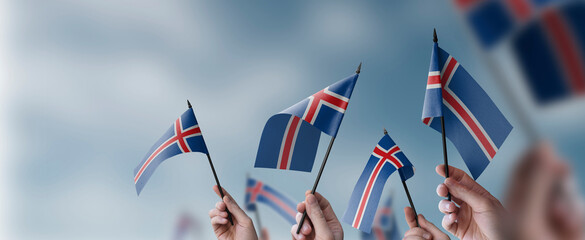 A group of people holding small flags of the Iceland in their hands