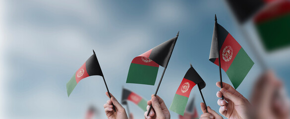 Fototapeta na wymiar A group of people holding small flags of the Afghanistan in their hands