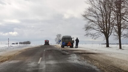 Broken Two lane asphalted suburban road repair at winter