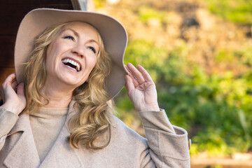 Attractive Smiling Middle Aged Woman Outside Wearing a Hat