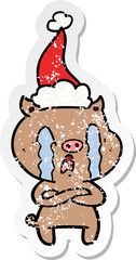 crying pig distressed sticker cartoon of a wearing santa hat