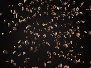 Aromatic coffee grains dropping against brown background