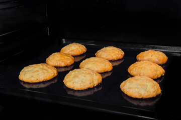 Nine baked homemade crunchy oatmeal cookies on metal sheet in oven. Dessert, cookery, baking,...