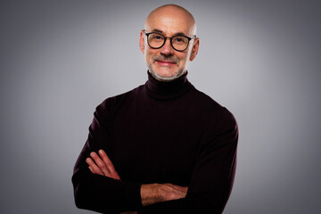 Studio portrait of a mid aged man wearing eyewear and turtleneck sweater against isolated background - 580745507