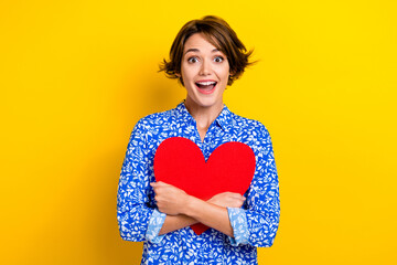 Photo of pretty impressed lady wear print shirt hugging red heart open mouth isolated yellow color background