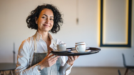 One mature woman caucasian waitress at cafe or restaurant carry tray