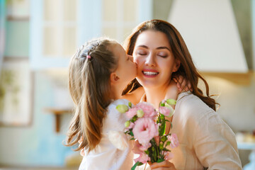 Daughter giving mother bouquet of flowers.