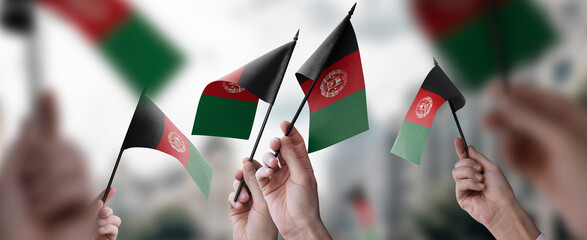 A group of people holding small flags of the Afghanistan in their hands
