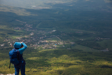 Fototapeta na wymiar Man stands on a mountain and looks far away nature hiking journey