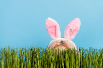 Photo of hide blond lady easter rabbit in grass wear ears isolated on blue color background