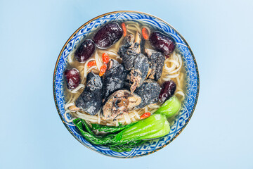 A bowl of black chicken noodles