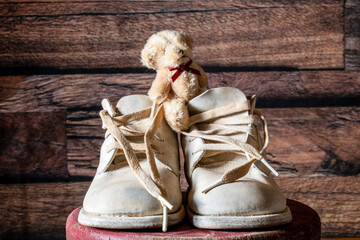 vintage 67 year old white leather baby shoes with small stuffed bear and original laces