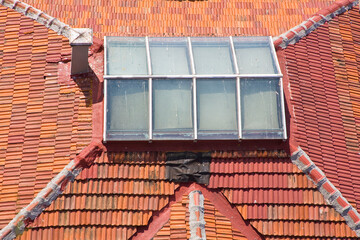 Old roof with tile called marseilles and skylight with chimney -