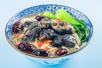 A bowl of black chicken noodles