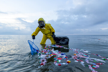 Slow violence. Volunteer biologist cleans up the ocean sea from plastic and corks wearing a suit and gas mask due to polluted waters. People protect the environment