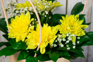 Flowers in a basket. Bouquet of yellow chrysanthemums
