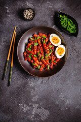 Tteokbokki, Teopokki fried rice cake in black bowl.