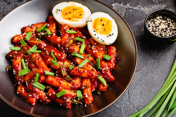 Tteokbokki, Teopokki fried rice cake in black bowl.