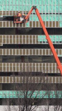 Vertical Video Construction Workers on Boom Lifts