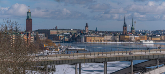 Panorama, down town view the long bridge V&auml;sterbron, Town City Hall, the old town islands with churches at the bay Riddarfj&auml;rden, a snowy sunny spring day in Stockholm