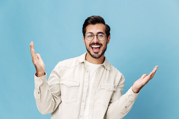 Fototapeta premium Portrait of a stylish man smile with teeth and happiness in glasses for farsightedness and myopia, on a blue background in a white T-shirt, space space