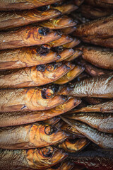 Obraz premium Dried smoked Atlantic or Baltic herrings, Clupea harengus, a herring in the family Clupeidae in a street food market in Vilnius, Lithuania, Europe, close up, vertical