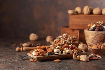 Mix of nuts and raisins on a brown rustic background.
