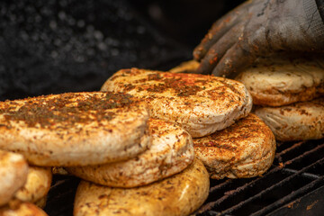 Smoking bio natural seasoned cheese with spices in a smoker in a street food market, close up