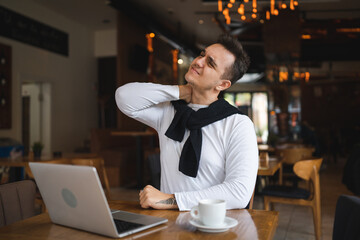 Fototapeta premium one man sit at the table at restaurant having neck pain or strain