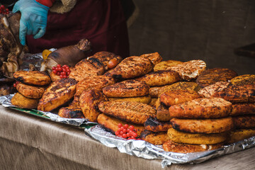 Smoking bio natural seasoned cheese with spices in a smoker in a street food market, close up