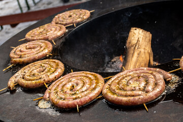 Spiral-rolled sausages prepared with minced meat, seasoned with tomato, pecorino cheese, basil, salt and pepper and stuffed into lamb intestine, grilled or roasted in a barbecue on the open fire