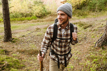 Young active man tourist hiking in forest