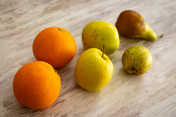 Manzanas, peras y naranjas en una mesa de madera
