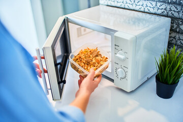 Person heating food in the microwave oven