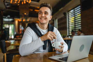 one man work on the computer laptop while sit at cafe or restaurant