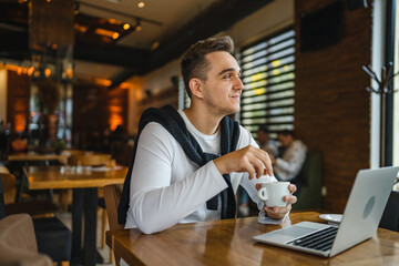 one man work on the computer laptop while sit at cafe or restaurant