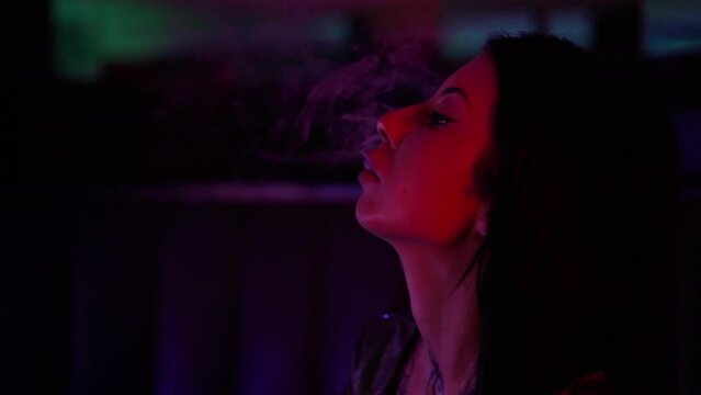 Party commercial video. Beautiful sexy female in club with red and blue lights dancing to music