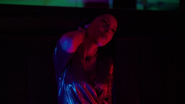Party commercial video. Beautiful sexy female in club with red and blue lights dancing to music