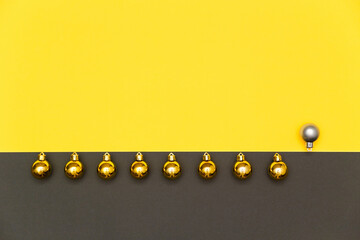 Christmas, New Year geometric background. Holiday decorations, line of gold and silver balls on bright yellow and grey backdrop. Flat lay, copy space.