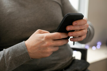 Adult male hands holding smartphone closeup. Businessman typing message in mobile phone messenger, chatting.