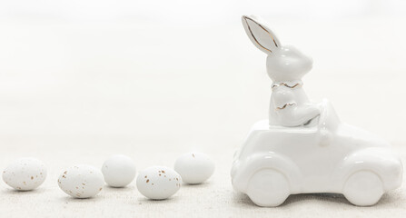 Decorative ceramic hare in a car and Easter eggs, close-up.