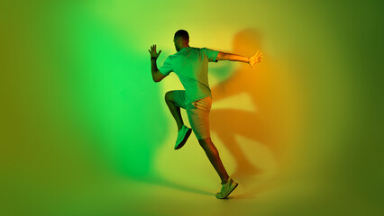 Fototapeta na wymiar African American Male Runner Running Training Over Green Neon Background