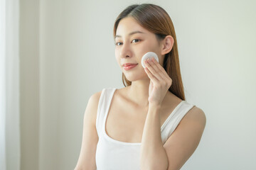 Happy beauty, attractive asian young woman, girl looking camera hand holding cotton pad, applying...