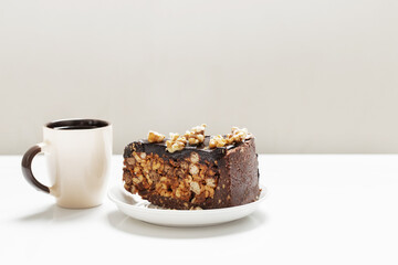 cup of coffee and piece of cake on white table