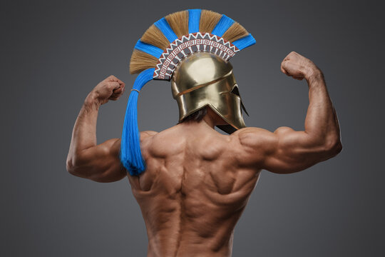 Studio shot of muscular man from antique greece against grey background.