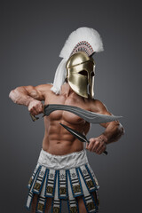 Shot of topless warrior from greece with perfect body against gray background.