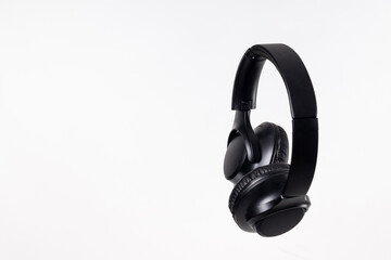 Black headband headphones to listen to music in free time, doing sports or traveling. Close-up on...