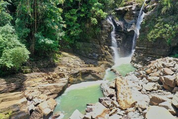 The spectacular waterfall Air Terjun Tengkulese on Flores which flows into a water basin surrounded...