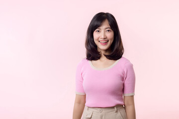 Fototapeta premium Portrait beautiful young asian woman model happy smile in pink sweater casual style fashion isolated on pink studio background. Attractive female person cheerful cute face portrait, Woman day concept.