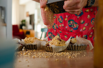 the process of making a cake by a man at home in the kitchen. the cook rubs the cookies on a grater